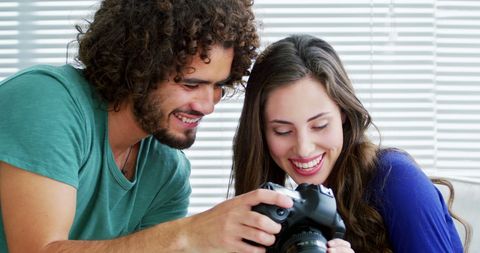 Happy Couple Sharing Photography Moments Together Indoors - Download Free Stock Images Pikwizard.com