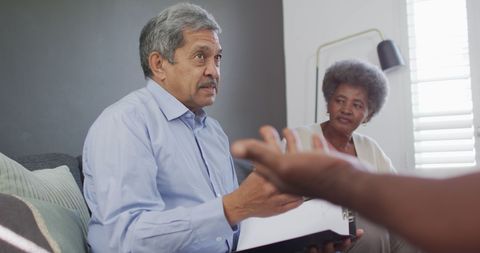 Senior Male Counsellor Advising Group of Diverse Friends at Home