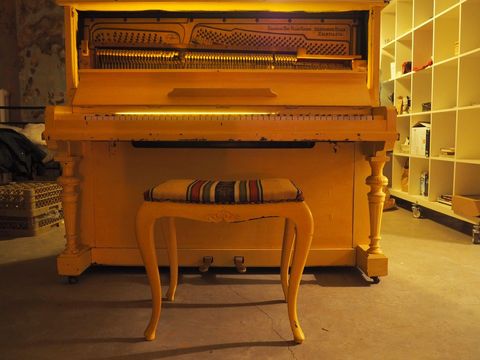 Vibrant Yellow Vintage Piano in Artistic Studio Setting