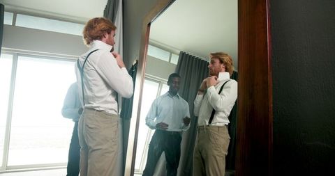 Groom and best man dressing for wedding celebration