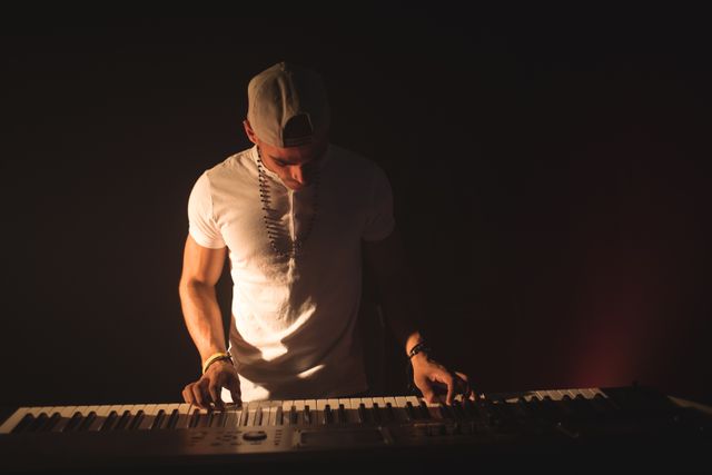 Male musician confidently playing piano in a dimly lit nightclub. Ideal for use in articles or advertisements related to live music, nightlife, entertainment, concerts, and musical performances. Can also be used for promoting music events, artist profiles, or nightlife venues.