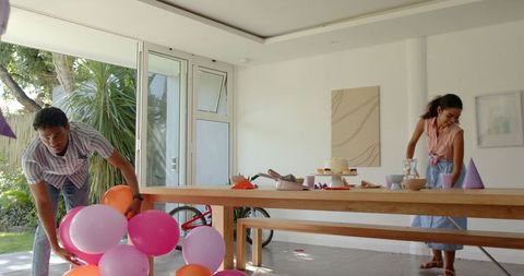 Couple preparing for party with colorful balloons