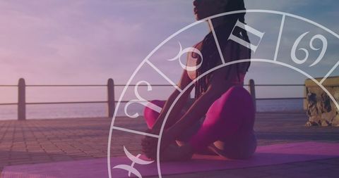 Horoscope Overlay on Woman Meditating by Seaside at Sunrise