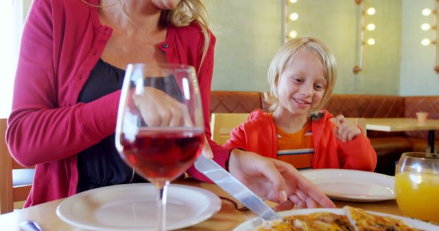 Smiling Mother and Child Enjoying a Meal Together in a Cozy Restaurant - Download Free Stock Images Pikwizard.com