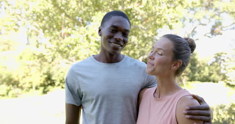 Smiling Diverse Couple Embracing in Sunlit Garden
