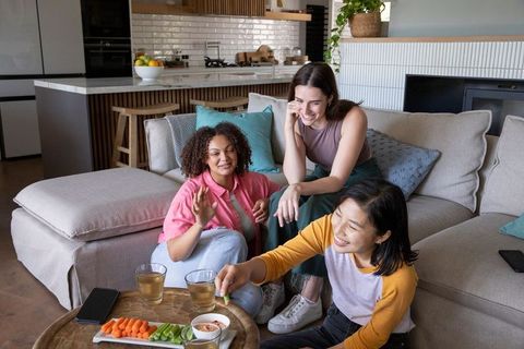 Female friends enjoying casual gathering in modern living room