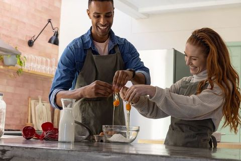 Smiling couple enjoying home cooking in modern kitchen