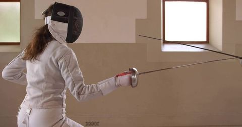 Female Fencer Practicing in Training Hall with Foil