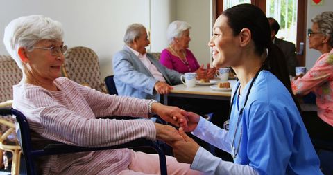 Caring doctor comforts senior in nursing home