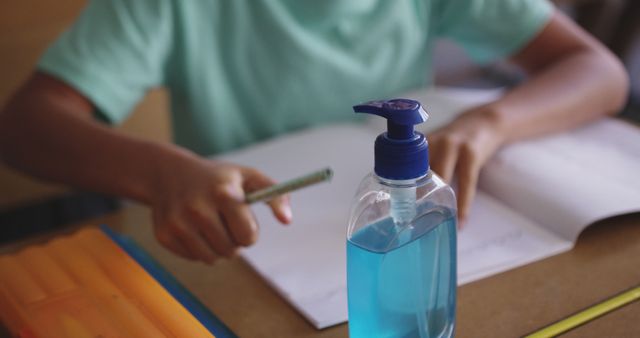 Student Writing During Class with Hand Sanitizer on Desk - Download Free Stock Images Pikwizard.com