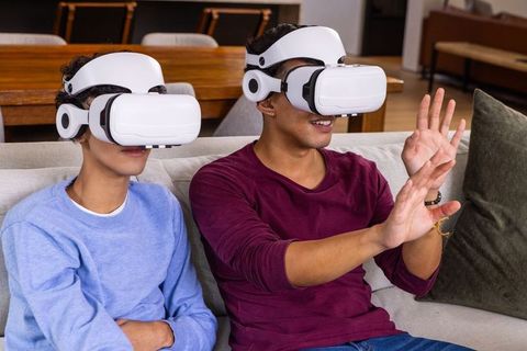 Friends Engaging in Virtual Reality Gaming on Couch in Living Room