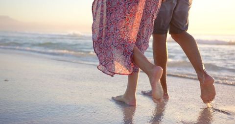 Romantic Beach Walk at Sunset Features Barefoot Couple