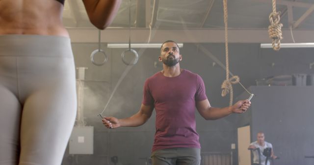 Focused man jumping rope in gym with fitness equipment - Download Free Stock Images Pikwizard.com