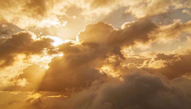 Golden Sunlit Cloudscape with Dramatic Crepuscular Rays and Silver Linings