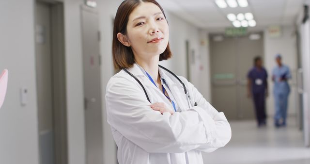 Image portrait of smiling asian female doctor standing in busy hospital corridor, copy space - Download Free Stock Photos Pikwizard.com