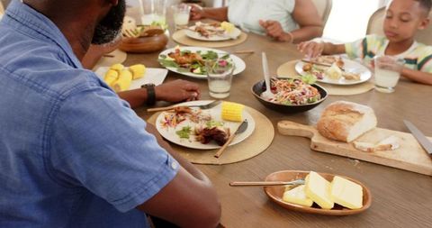Family Enjoying Meal Around Dining Table in Cozy Home Environment