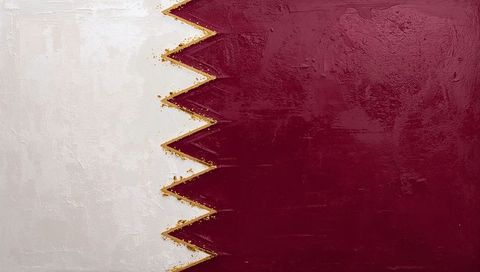 Qatar flag painted on textured canvas showing gold-flecked serrated edge
