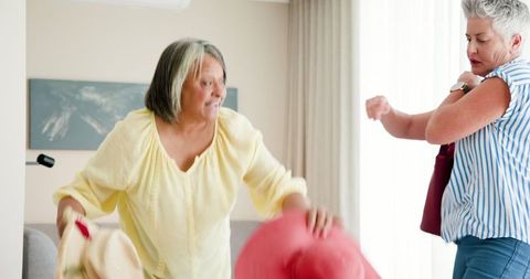 Senior Lesbian Couple Packing for Tropical Vacation Adventure