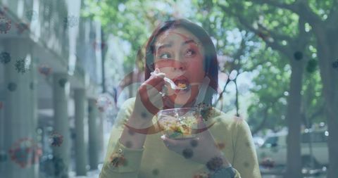 Woman eating outdoors with overlay of biohazard symbol