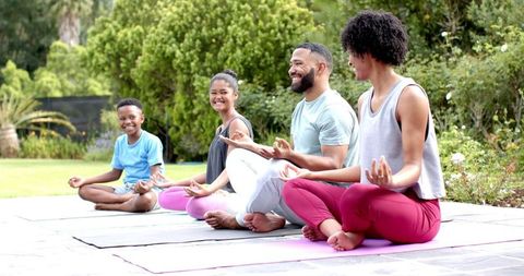 Family Yoga Session Outdoors with Smiling African American Parents and Children