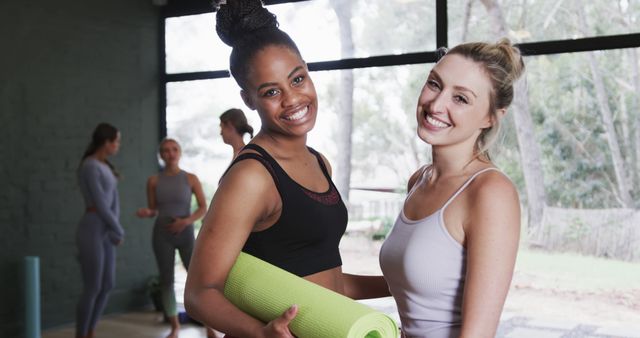 Diverse Women Smiling in Yoga Studio Holding Yoga Mats - Download Free Stock Images Pikwizard.com
