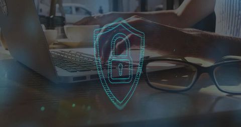 Remote work cybersecurity typing on laptop with holographic shield padlock overlay