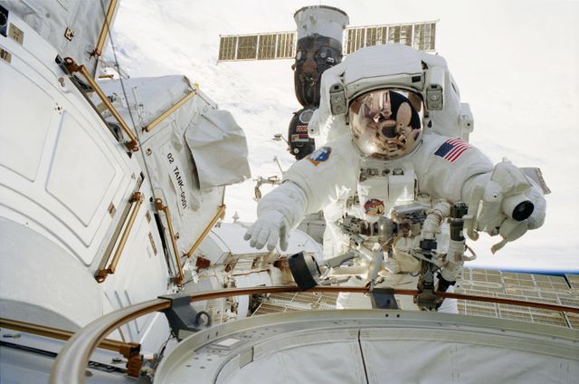 In this photograph, STS-113 astronaut and mission specialist John B. Herrington participates in the mission's first space walk. The opened hatch of the Quest Airlock can be seen reflected in Herrington's helmet visor. The airlock, located on the starboard side of the Unity Node I on the International Space Station (ISS), makes it easier to perform space walks, and allows both Russian and American space suits to be worn when the Shuttle is not docked with the ISS. American suits will not fit through Russian airlocks at the Station. STS-113, the 16th American assembly flight and 112th overall American flight to the ISS, launched on November 23, 2002 from Kennedy's launch pad 39A aboard the Space Shuttle Orbiter Endeavour. The main mission objective was the installation and activation of the Port 1 Integrated Truss Assembly (P1). The first major component installed on the left side of the Station, the P1 truss provides an additional three External Thermal Control System radiators. Weighing in at 27,506 pounds, the P1 truss is 45 feet (13.7 meters) long, 15 feet (4.6 meters) wide, and 13 feet (4 meters) high. Three space walks, aided by the use of the Robotic Manipulator Systems of both the Shuttle and the Station, were performed in the installation of P1.