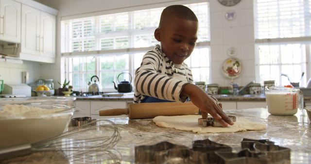 Young African-American boy baking with cookie cutters in sunny kitchen - Download Free Stock Images Pikwizard.com