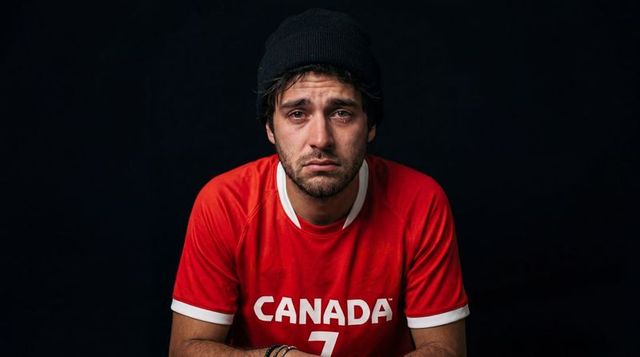 Tearful canadian sports fan wearing canada jersey number 7 and beanie, melancholy portrait