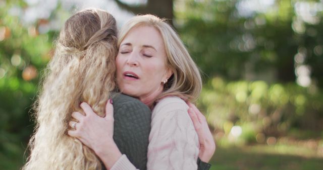 Image of emotional caucasian senior mother and adult daughter hugging in garden. Family, love and togetherness concept digitally generated image.