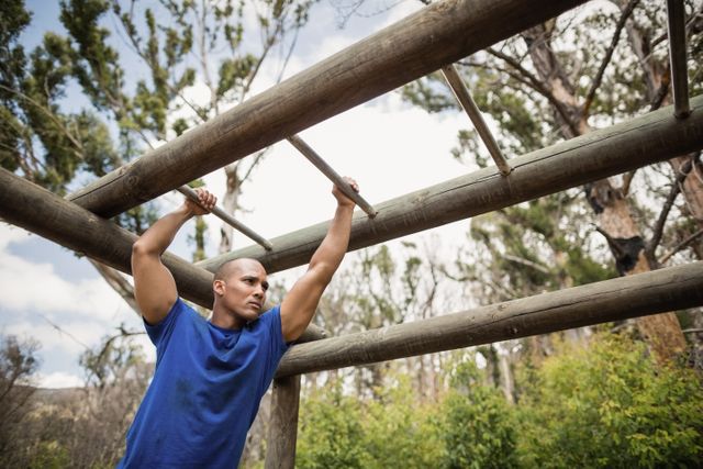 Fit man climbing monkey bars during obstacle course - Download Free Stock Photos Pikwizard.com