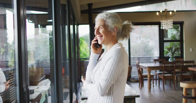 Senior biracial woman talking on smartphone. retirement and senior lifestyle, spending time alone at home.