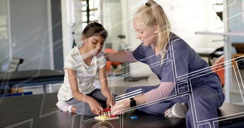 Pediatric therapist guiding child during pegboard fine motor play on therapy mat