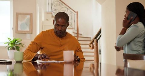 Mature couple discussing finances while reviewing documents at home