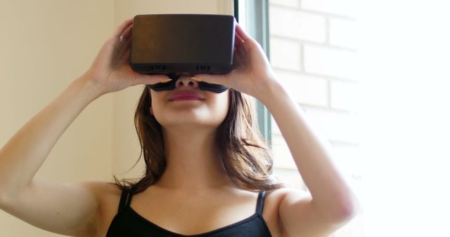 Young woman enjoying immersive experience with virtual reality headset - Download Free Stock Images Pikwizard.com