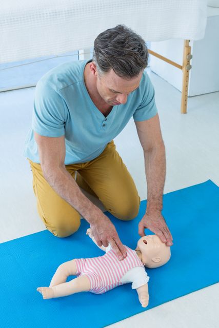 Paramedic practising resuscitation on dummy in clinic