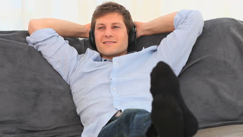 Casual Man Relaxing with Headphones on Couch