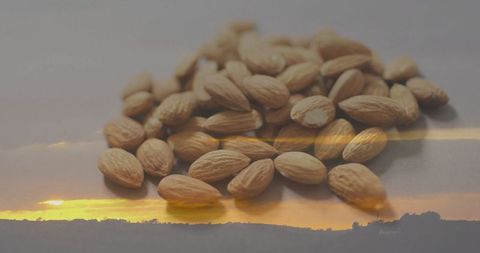 Whole Almonds on Reflective Surface with Sunset in Background