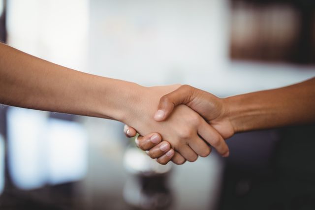 Cropped hands of business people shaking hands in office