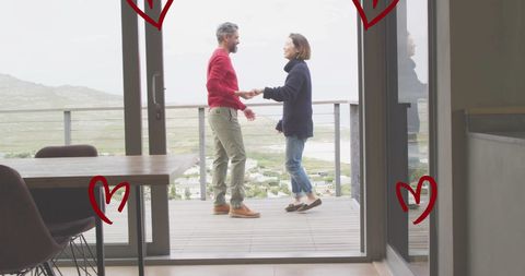 Couple dancing on balcony surrounded by heart illustrations