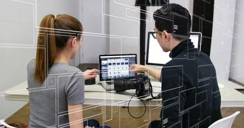 Creative colleagues reviewing digital work in modern editing studio