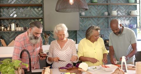 Senior Friends Joyfully Preparing Meal in Modern Kitchen