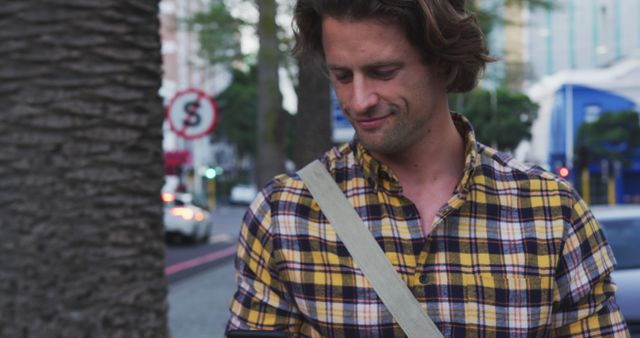 Man with Checkered Shirt Using Smartphone in City Landscape - Download Free Stock Images Pikwizard.com