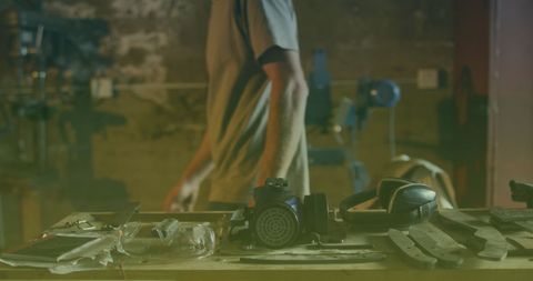 Workshop Table with Tools and Worker in Background