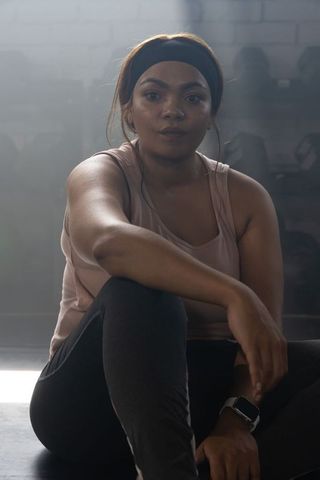 African american woman resting after intense weightroom workout, focused and resilient