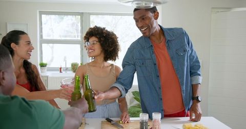 Diverse Friends Celebrating with Beers in Bright Kitchen