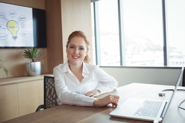 Portrait of smiling young businesswoman sitting at office desk