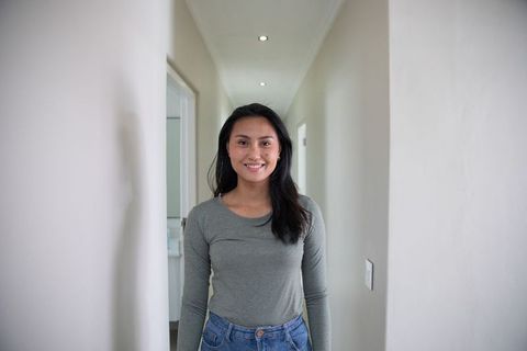 Asian Woman Standing in Hallway with Modern Interior Design