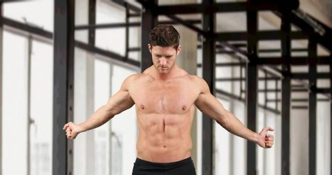 Muscular Athletic Man Warming Up in Modern Gym Environment
