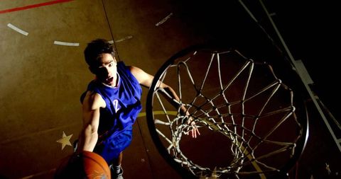 Energetic Basketball Player Dunking on indoor Basketball Court